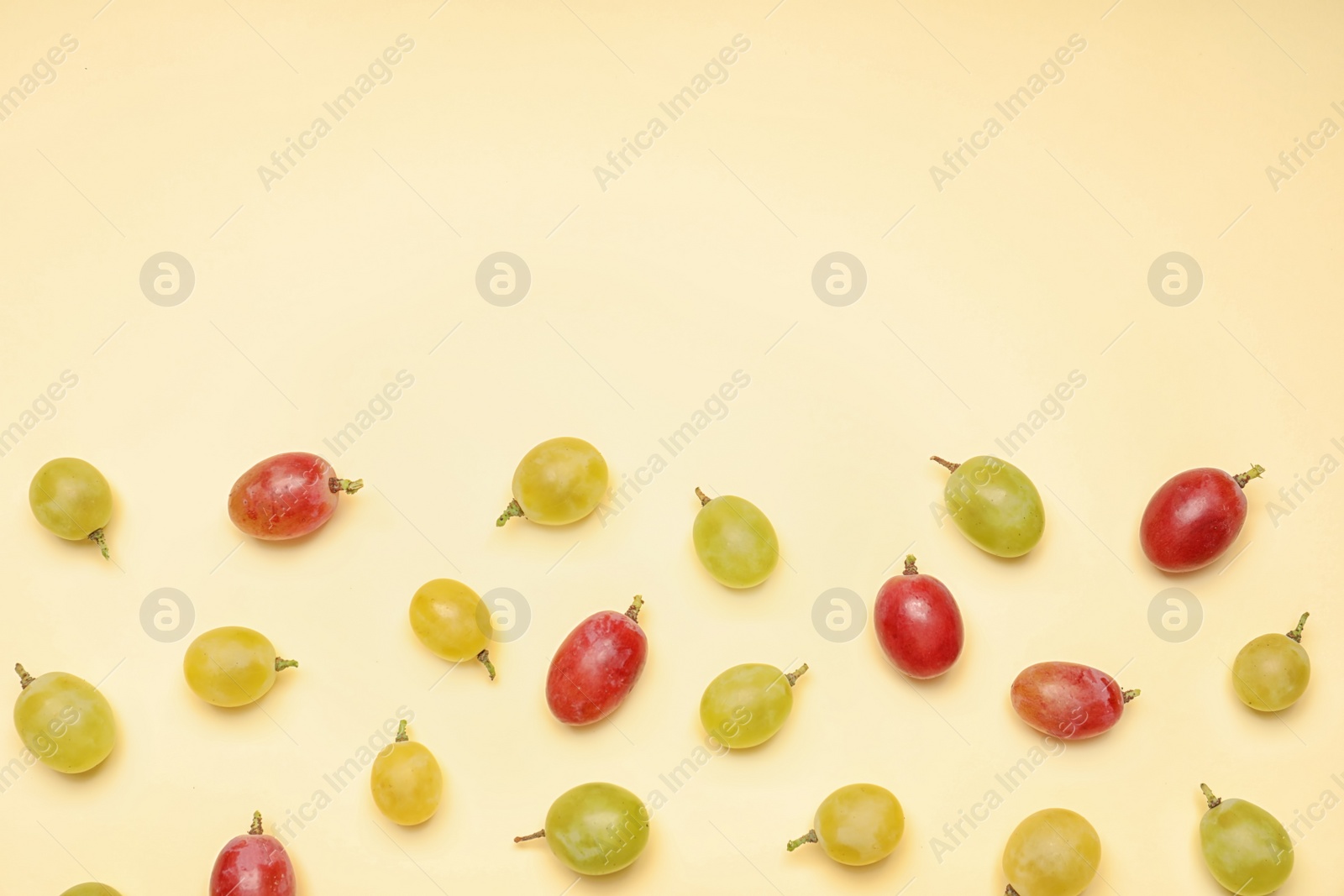 Photo of Fresh ripe juicy grapes on color background, top view. Space for text