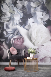 Photo of Comfortable armchair near wall with floral print. Stylish room interior