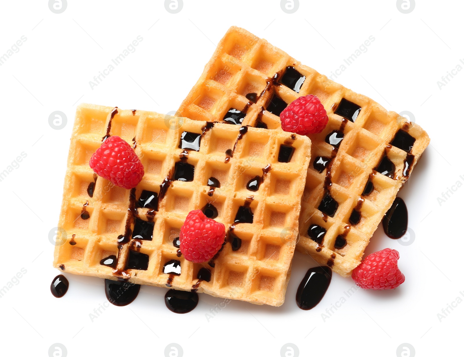 Photo of Delicious waffles with raspberries and chocolate syrup on white background, top view