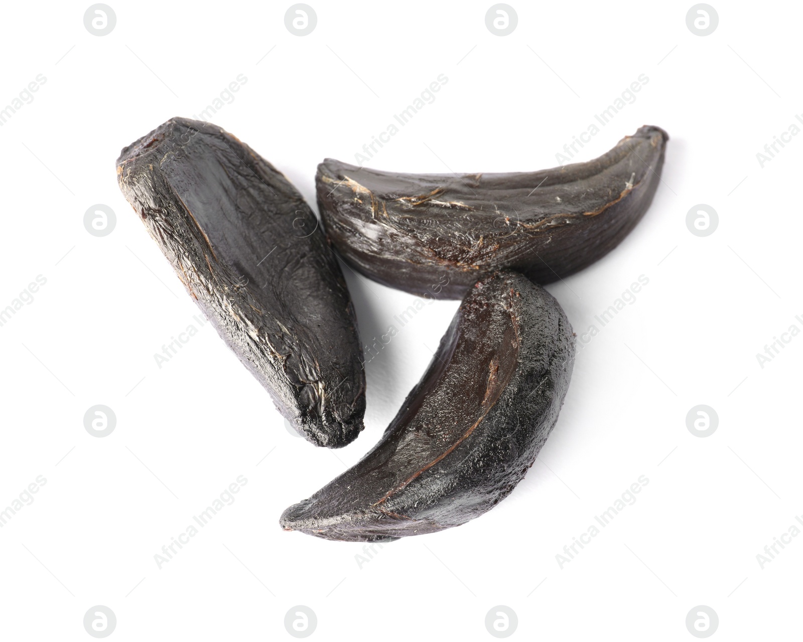 Photo of Cloves of aged black garlic on white background, view from above