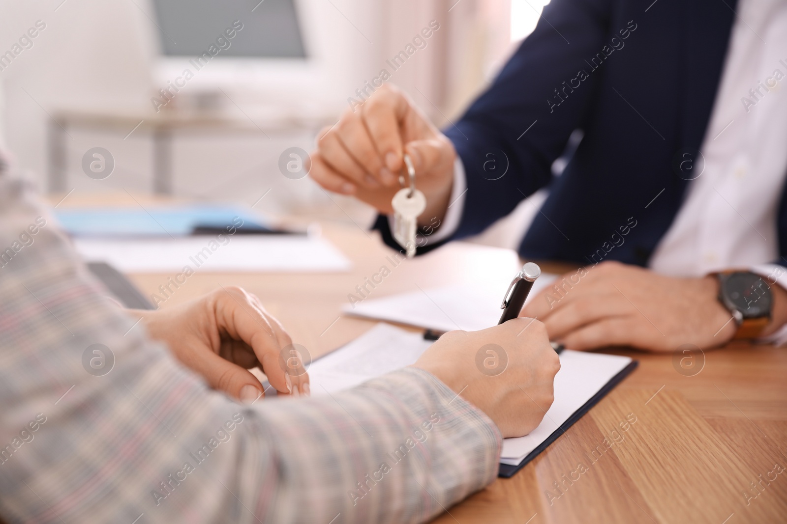 Photo of Real estate agent working with client in office, closeup