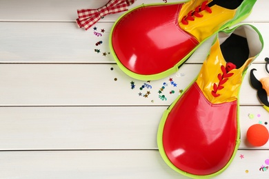 Photo of Flat lay composition with clown's items on white wooden table, space for text