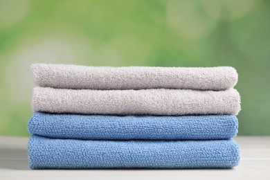 Photo of Soft folded towels on white wooden table