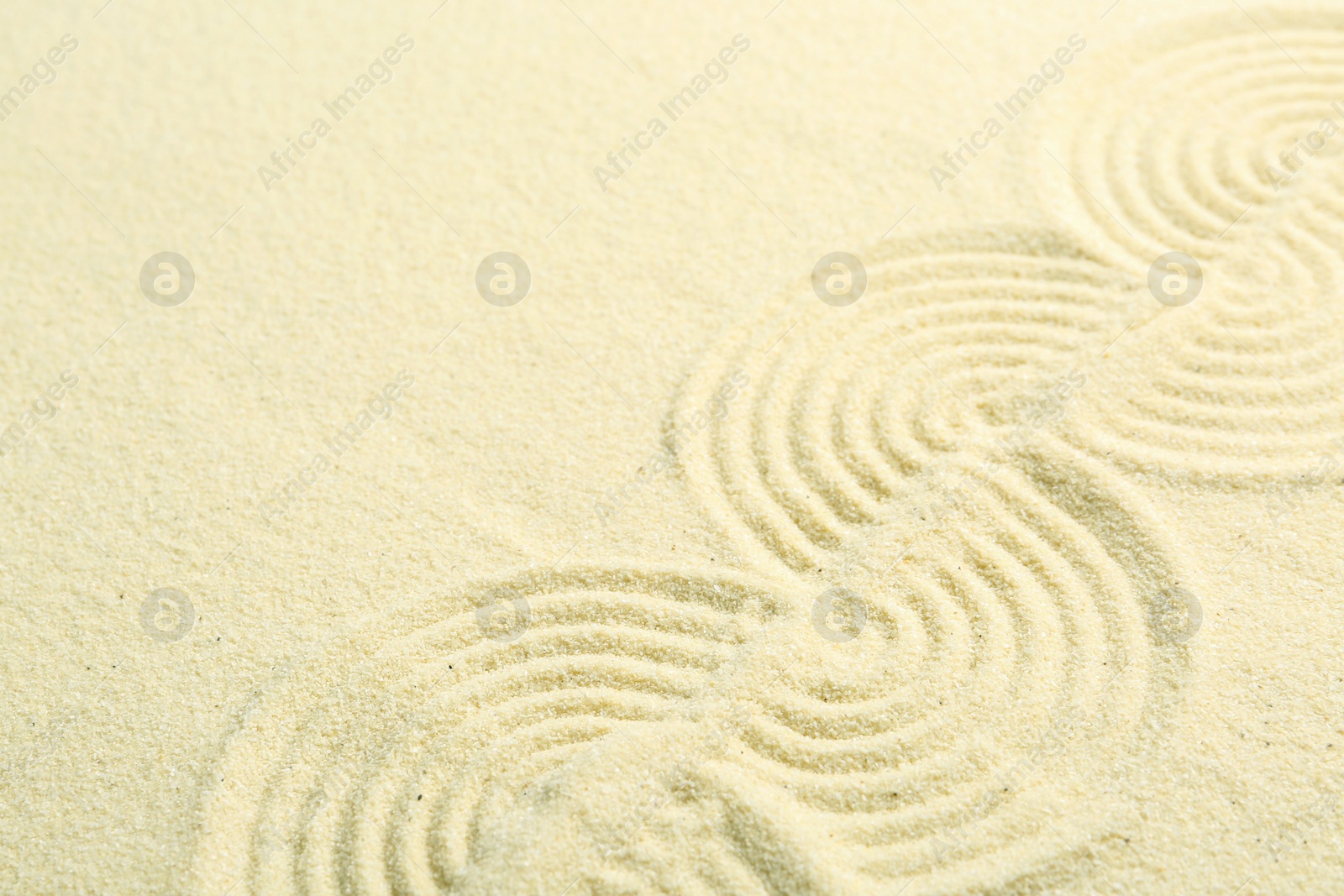 Photo of Zen rock garden. Wave pattern on beige sand
