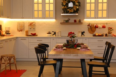 Photo of Cozy dining room interior with beautiful Christmas wreath and festive decor