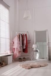 Modern dressing room interior with clothing rack and mirror