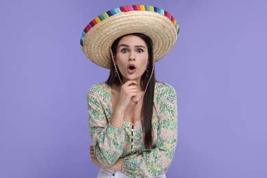 Photo of Surprised woman in Mexican sombrero hat on violet background