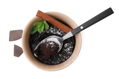 Tasty chocolate mug pie with cinnamon stick, mint and spoon isolated on white, top view. Microwave cake recipe