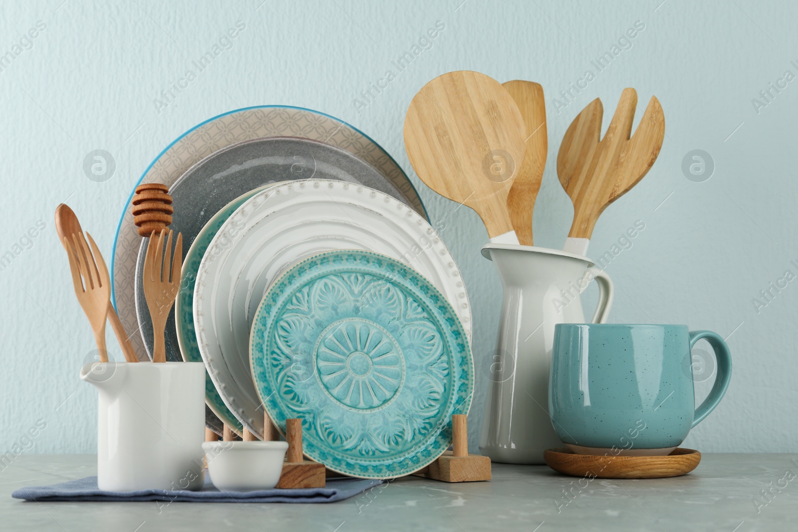 Photo of Set of kitchenware on grey marble table near light wall. Modern interior design