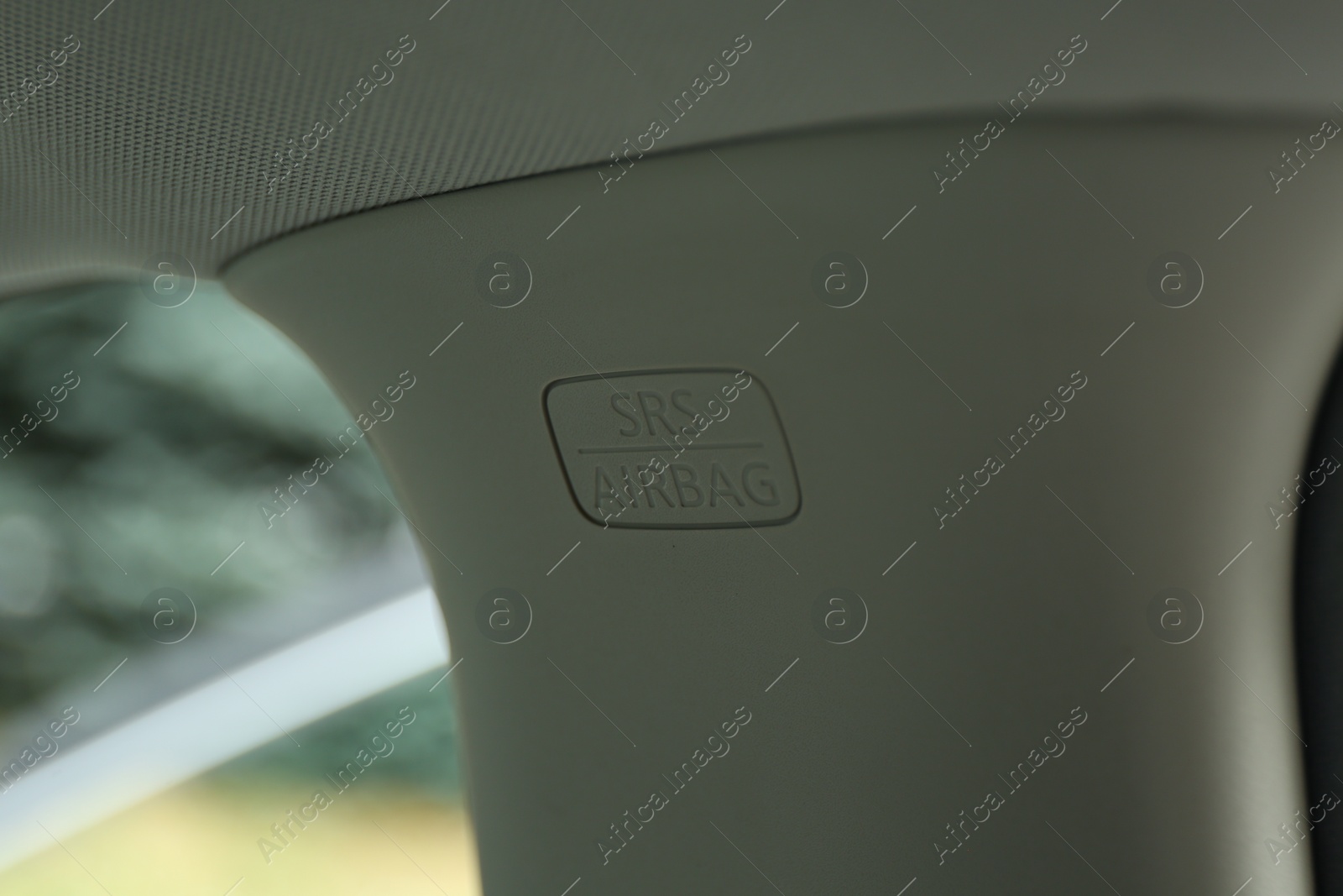 Photo of Safety airbag sign on center pillar panel in car, closeup