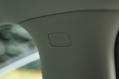 Photo of Safety airbag sign on center pillar panel in car, closeup