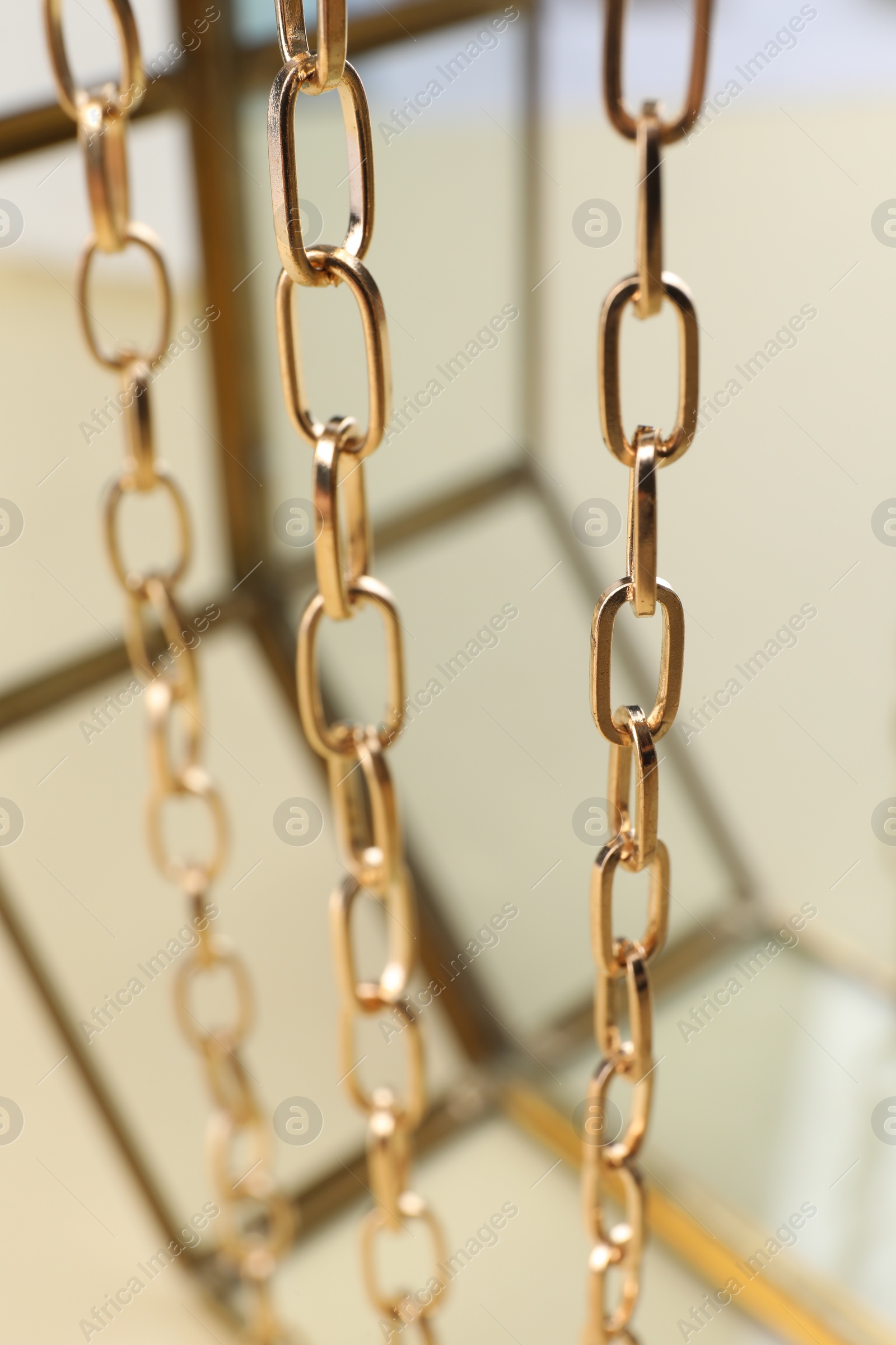 Photo of Stand with different metal chains, closeup. Luxury jewelry