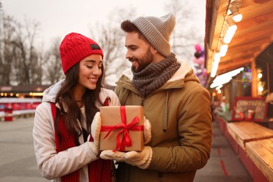 Lovely couple with Christmas present at winter fair