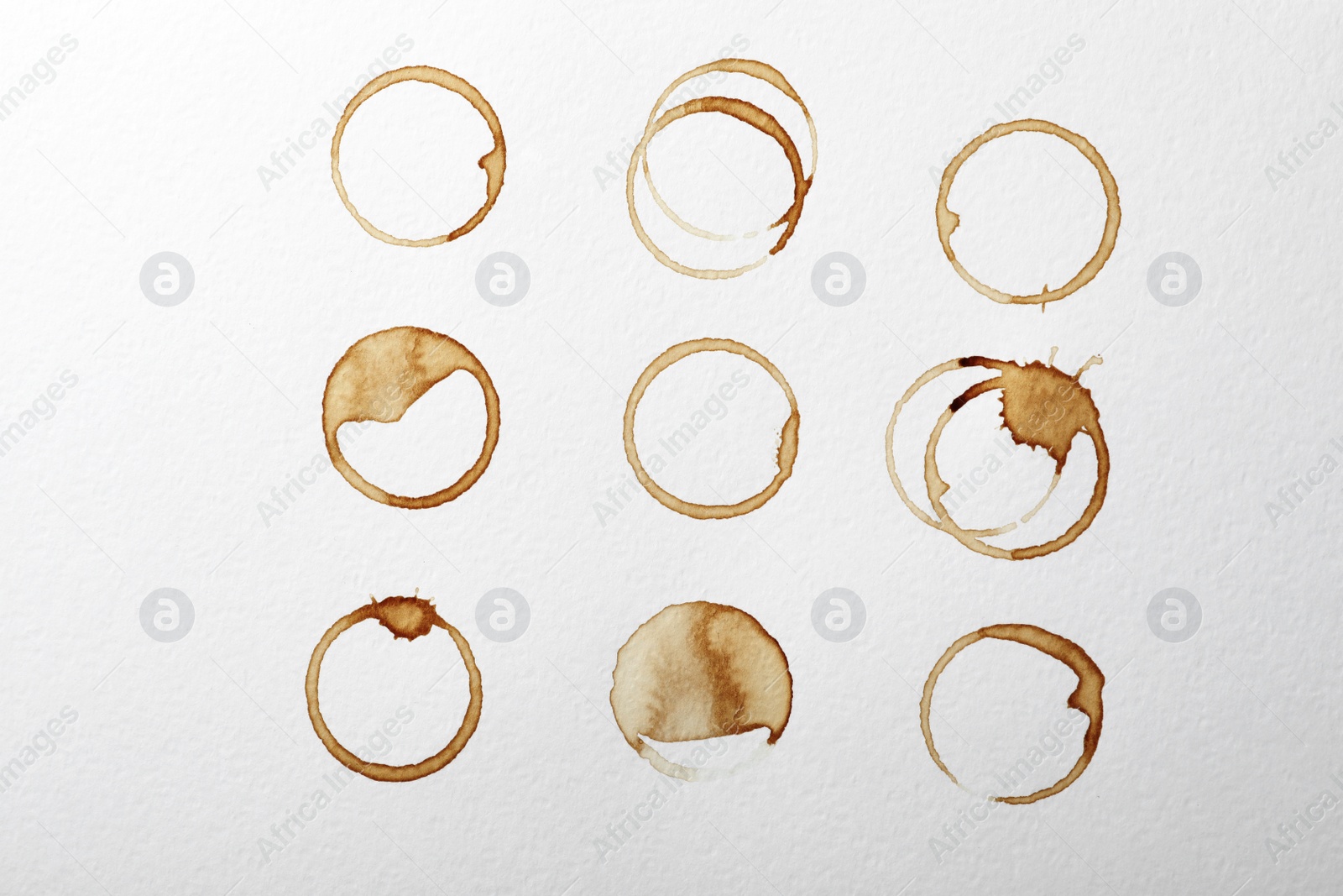 Photo of Dried coffee cup stains on white background, top view