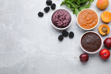 Different puree in bowls and fresh fruits on light grey table, flat lay. Space for text