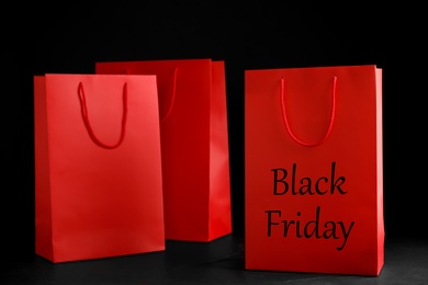 Photo of Paper shopping bags on dark background. Black Friday sale