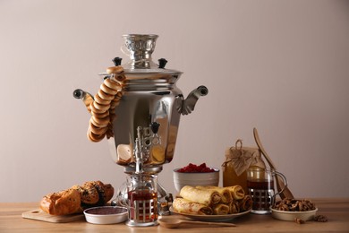 Photo of Traditional Russian samovar with treats on wooden table