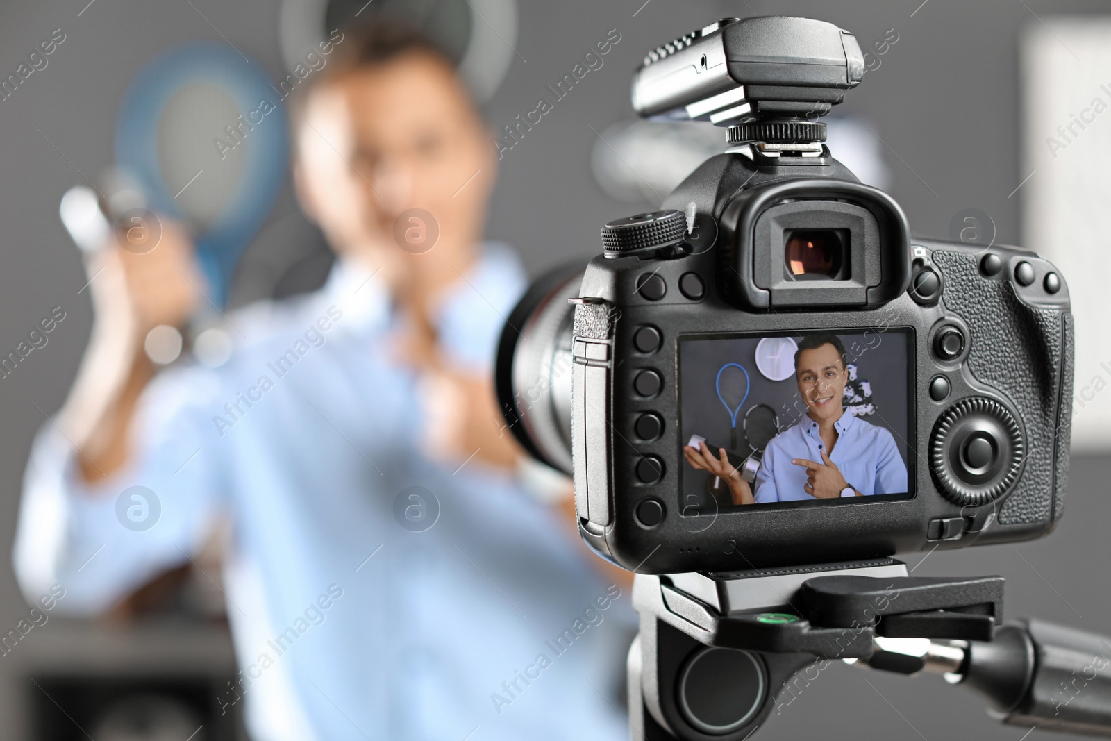 Photo of Sport blogger recording video indoors, selective focus on camera display. Space for text