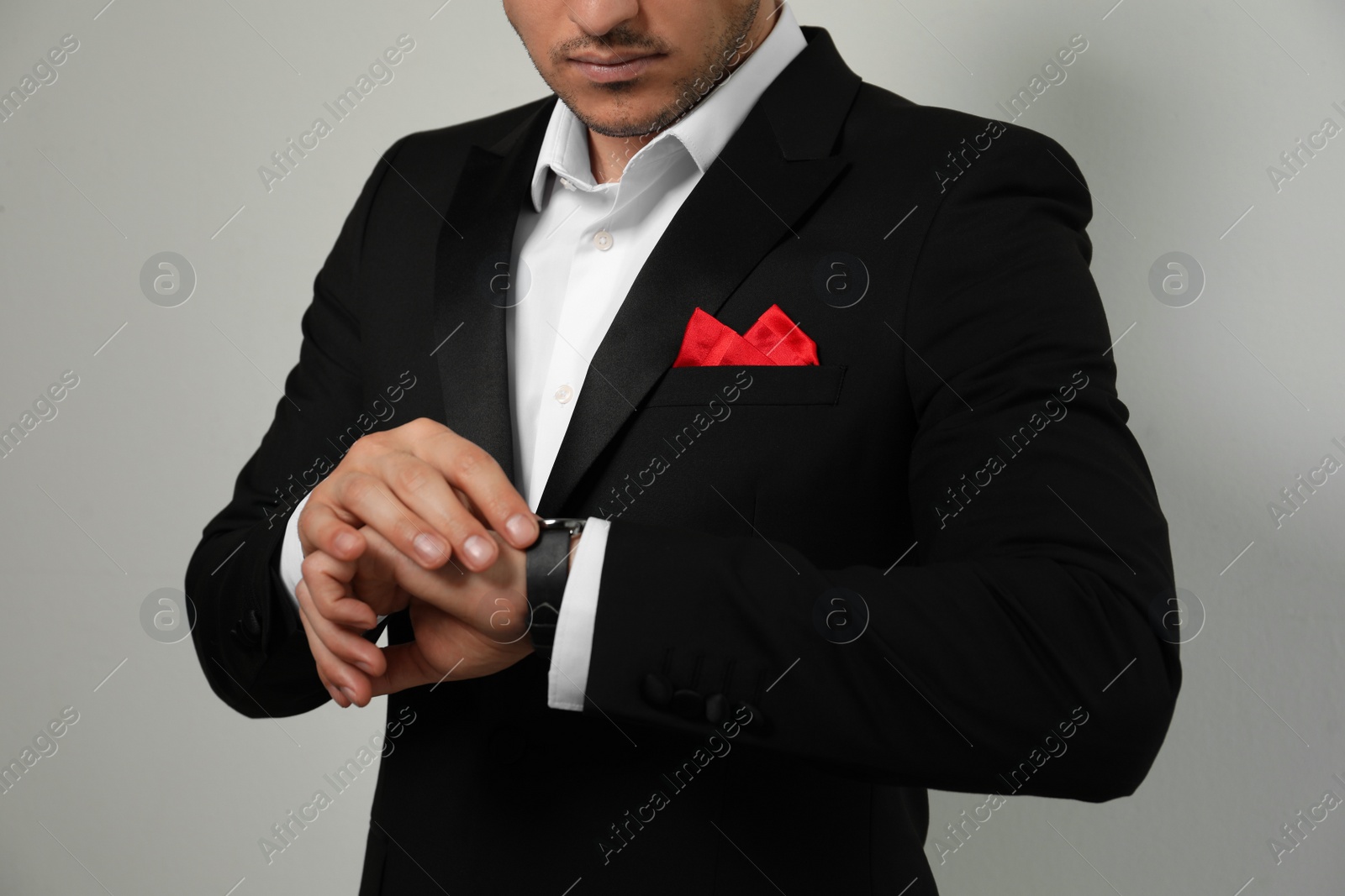 Photo of Man with handkerchief in breast pocket of his suit on light background, closeup