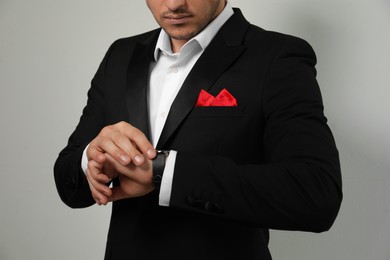 Man with handkerchief in breast pocket of his suit on light background, closeup