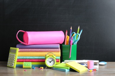 Different school stationery on table near chalkboard