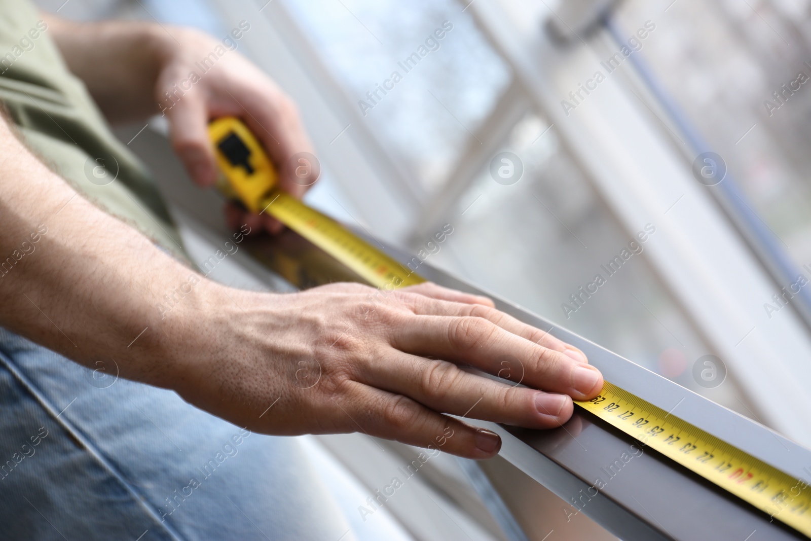 Photo of Man measuring metal railing, closeup. Construction tool