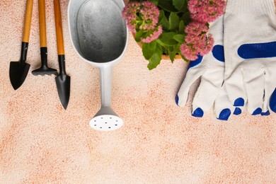 Flat lay composition with watering can and gardening tools on color textured background