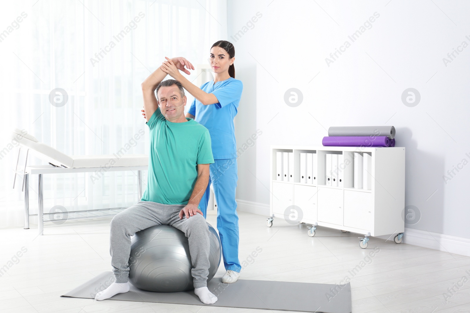 Photo of Doctor working with patient in hospital. Rehabilitation exercises