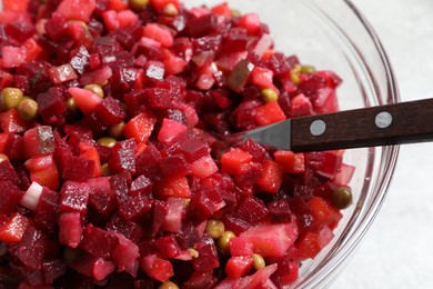 Photo of Bowl of delicious fresh vinaigrette salad on table, closeup