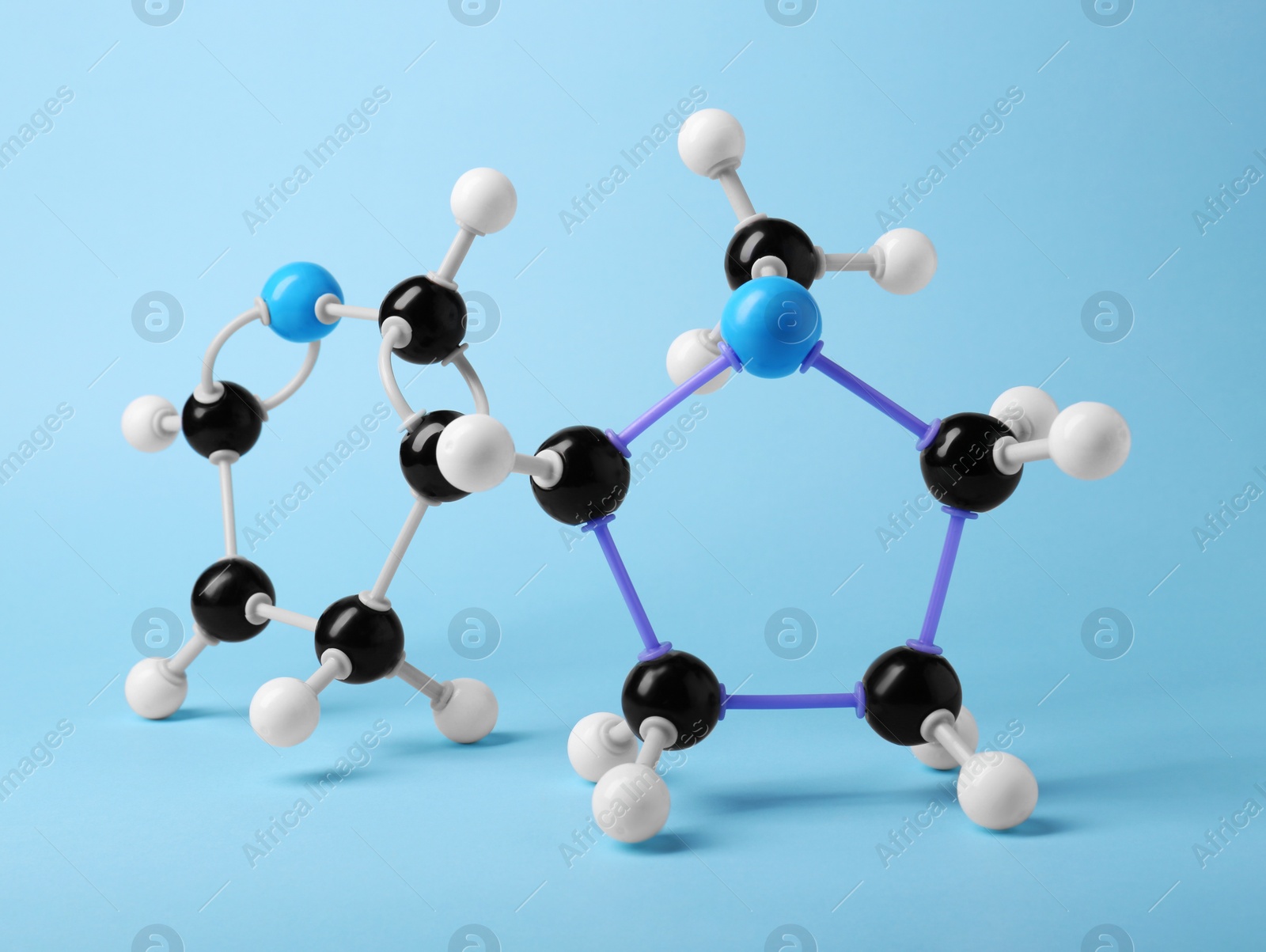 Photo of Molecule of nicotine on light blue background. Chemical model