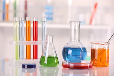 Laboratory analysis. Different glassware with liquids on white table against blurred background