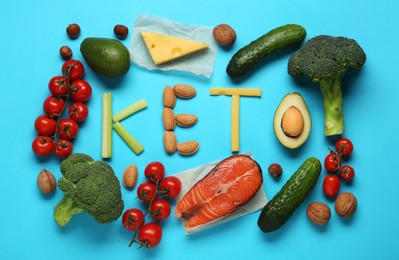 Photo of Word Keto made with products surrounded by different food for low carb diet on light blue background, flat lay