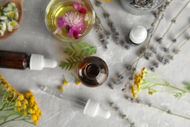 Photo of Flat lay composition with essential oils and flowers on light background
