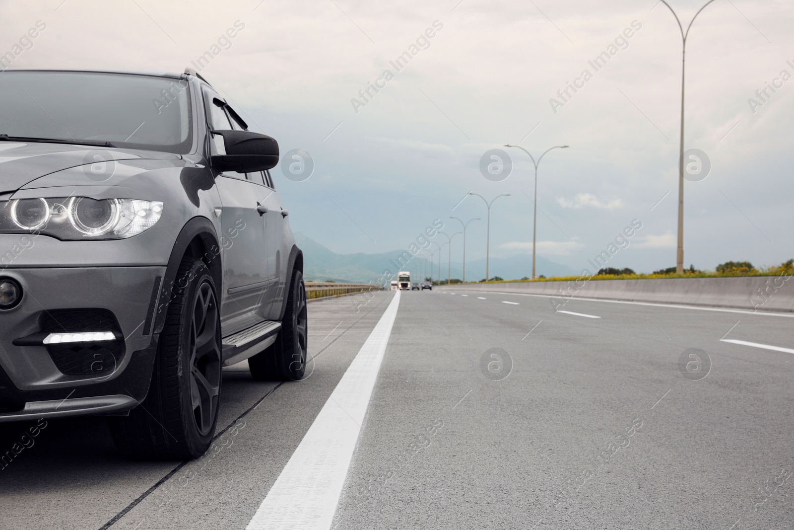 Photo of Grey modern car parked on asphalt road
