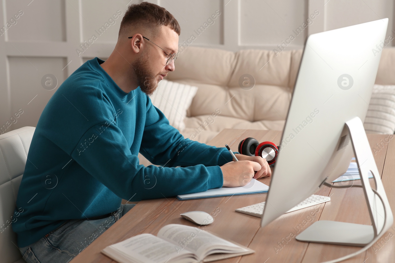 Photo of Online test. Man studying at desk indoors