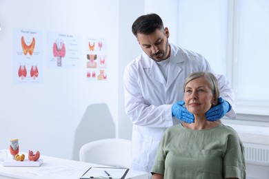 Endocrinologist examining thyroid gland of patient at hospital. Space for text