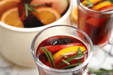 Glass cup of tasty mulled wine with spices on table, closeup