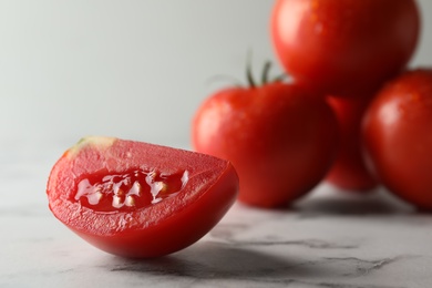 Fresh ripe tomatoes on white marble table, closeup