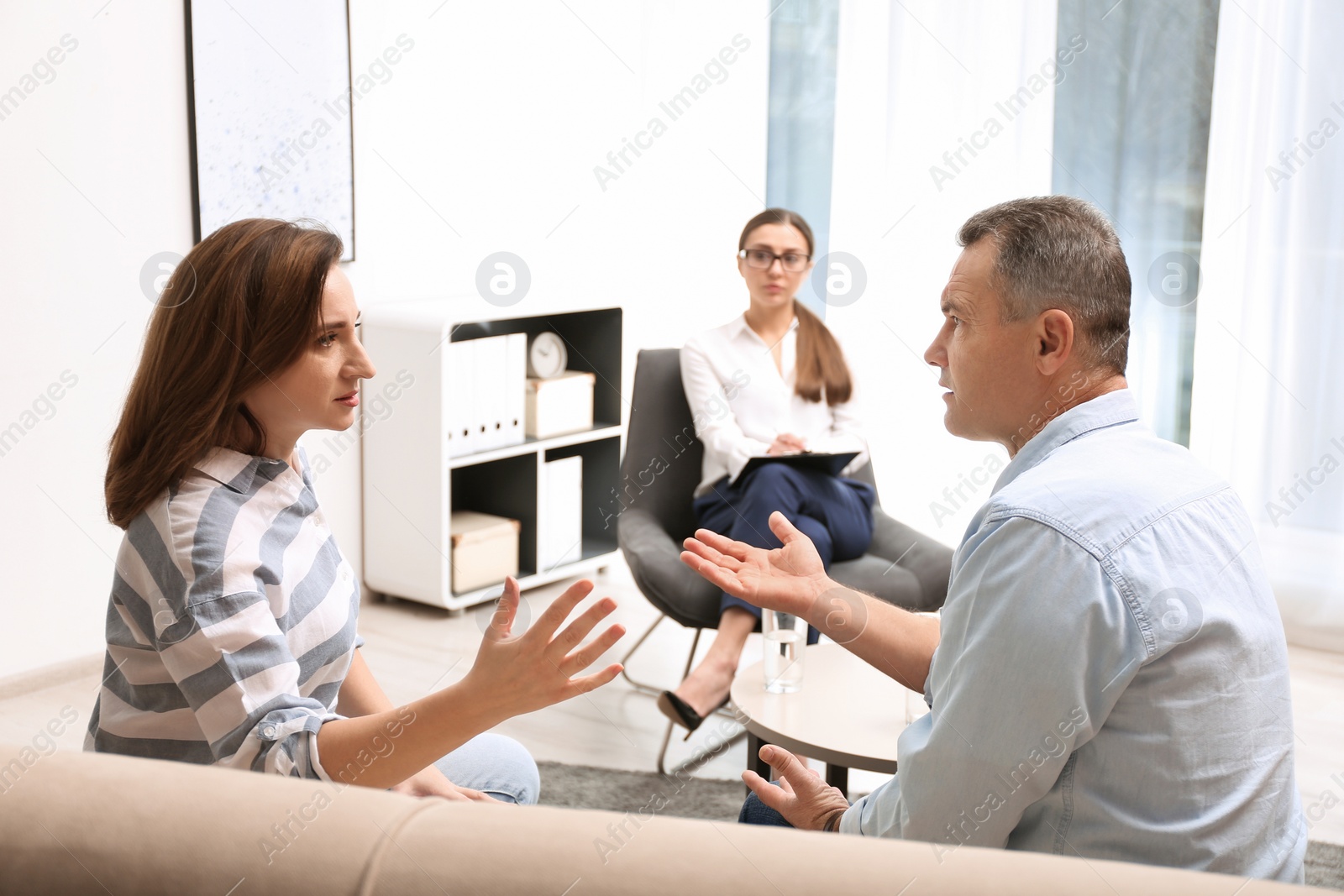 Photo of Psychotherapist working with couple in office. Family counselling