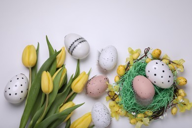 Photo of Flat lay composition with beautiful flowers and eggs on white background. Easter celebration