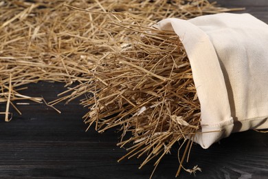 Dried straw in burlap sack on dark wooden table