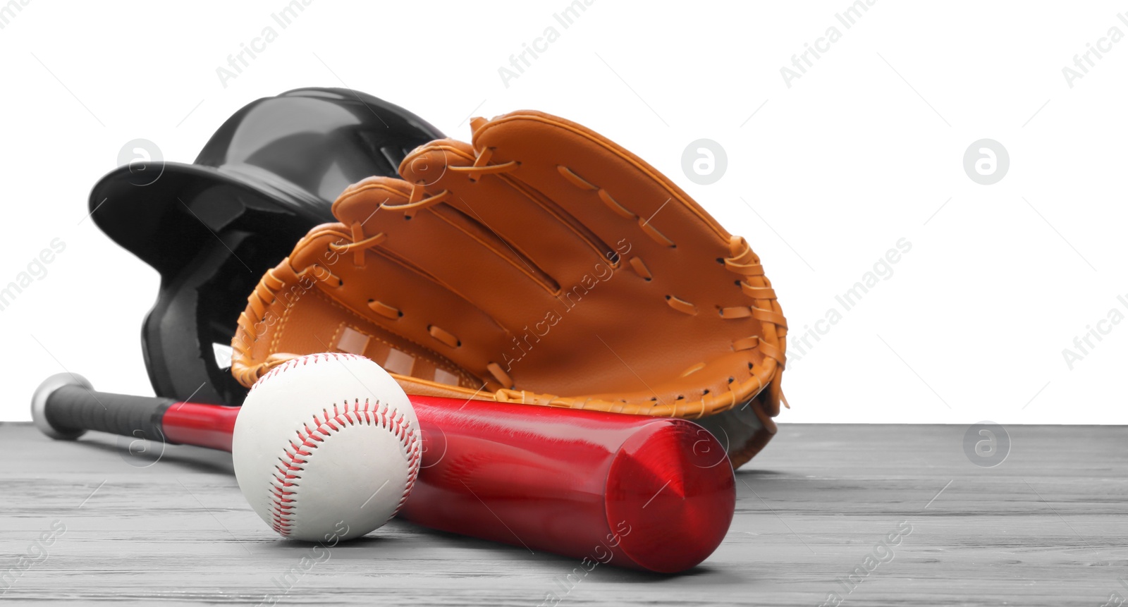 Photo of Baseball glove, bat, ball and batting helmet on grey wooden table against white background