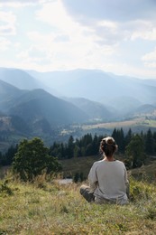 Photo of Woman enjoying beautiful mountain landscape, back view. Space for text