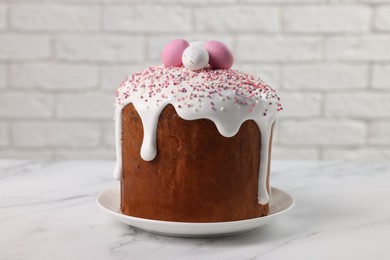 Tasty Easter cake with decorative sugar eggs on white marble table