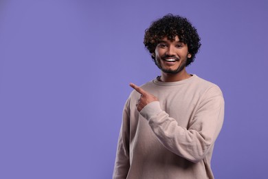 Handsome smiling man on violet background, space for text