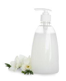 Dispenser with liquid soap and freesia flowers on white background
