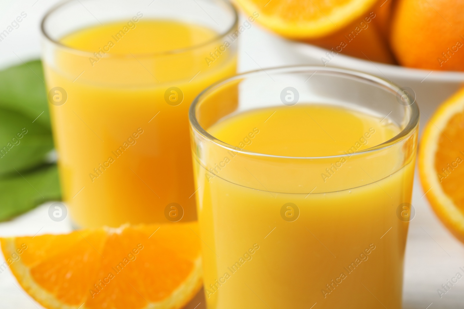 Photo of Glasses of delicious fresh orange juice, closeup