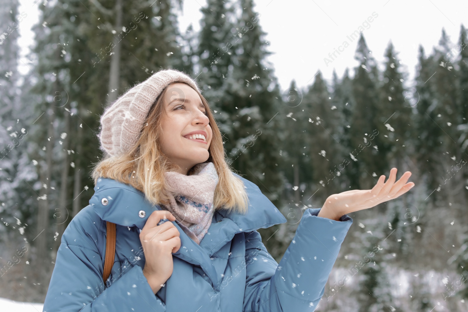 Photo of Happy young woman in warm clothes outdoors. Winter vacation