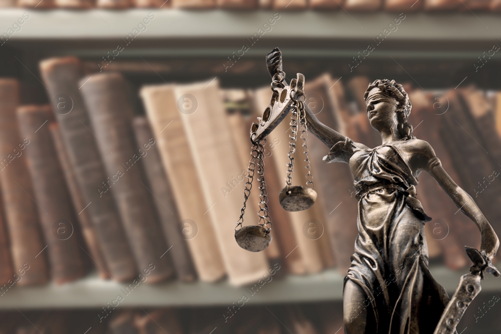 Image of Law and wisdom. Statue of Lady Justice near shelves with books, space for text