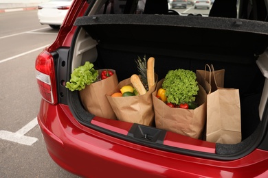 Photo of Bags full of groceries in car trunk outdoors